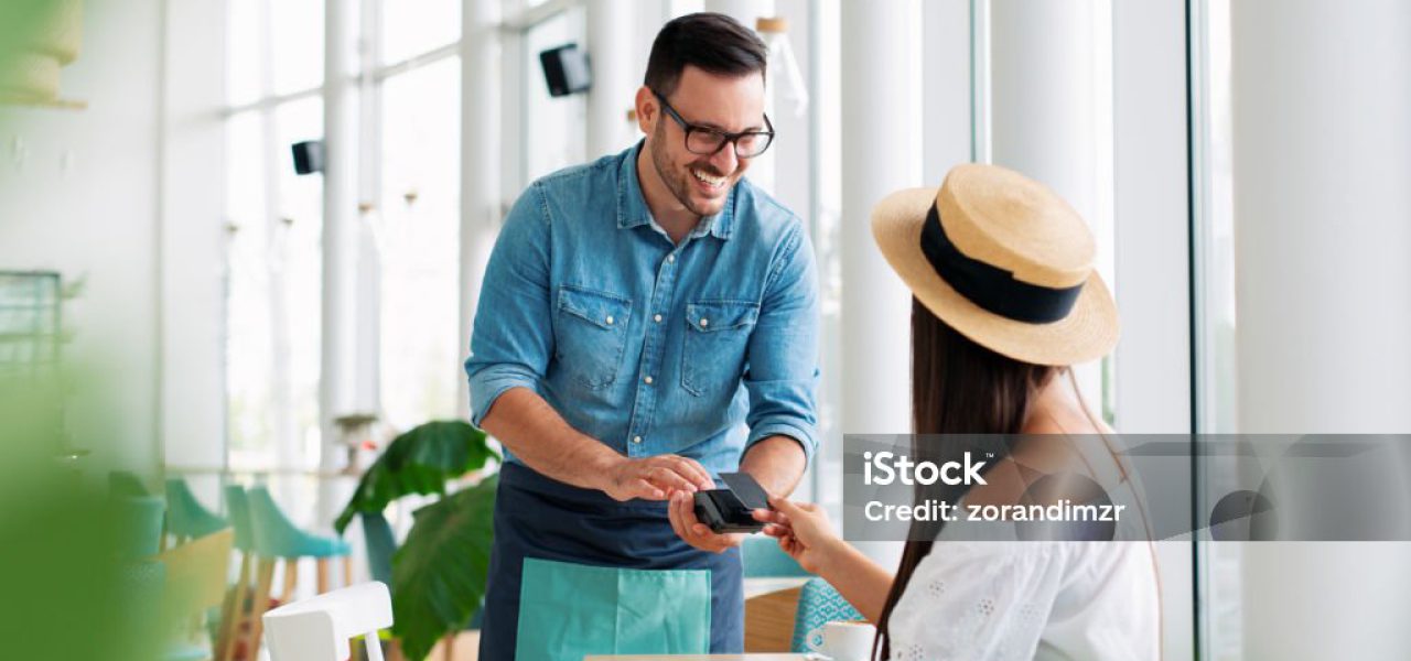 Woman paying by credit card in restaurant